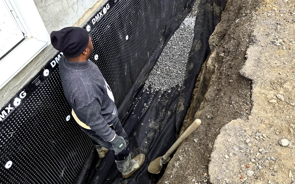 Drainage stone being installed against an exterior dimple-board membrane