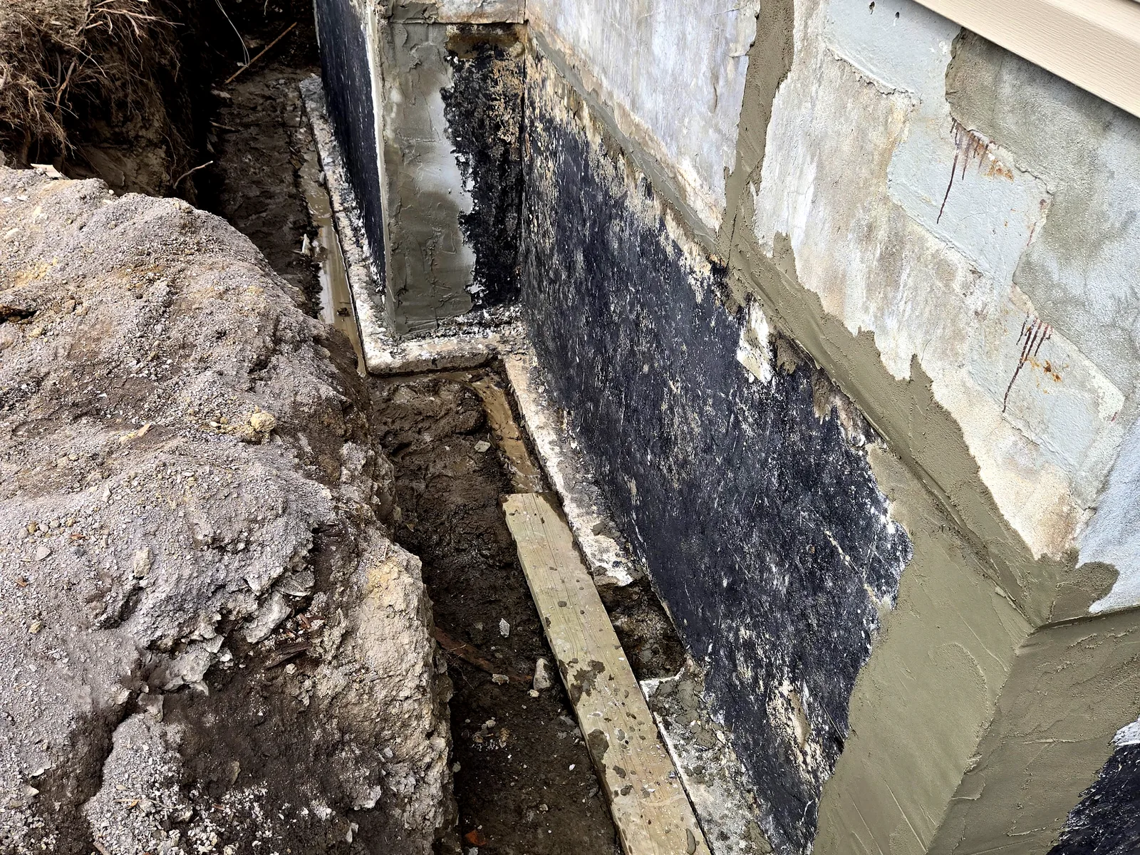 Foundation wall freshly parged with a new finish coat